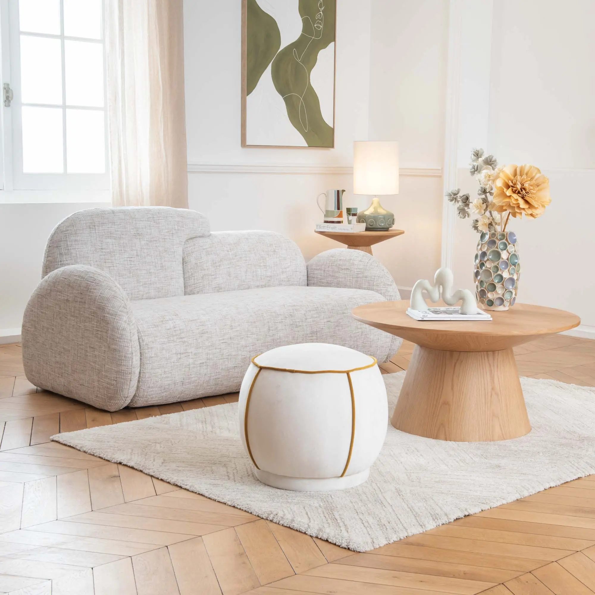 Salón de Amadeus con sofá de bouclé blanco y mesa de centro de madera